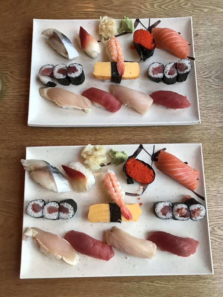 Two plates of nigiri and sushi rolls